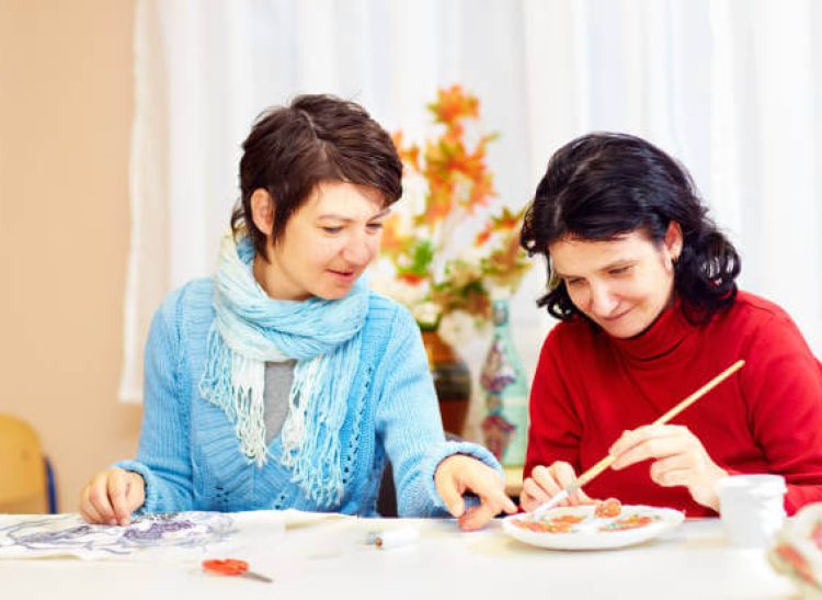 Support worker helping a person with disability develop life skills through hands-on activities in Dubbo